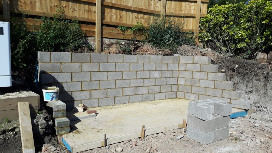 A reinforced concrete block retaining wall was constructed behind the shed base. A reinforced concrete block retaining wall was constructed behind the shed base.