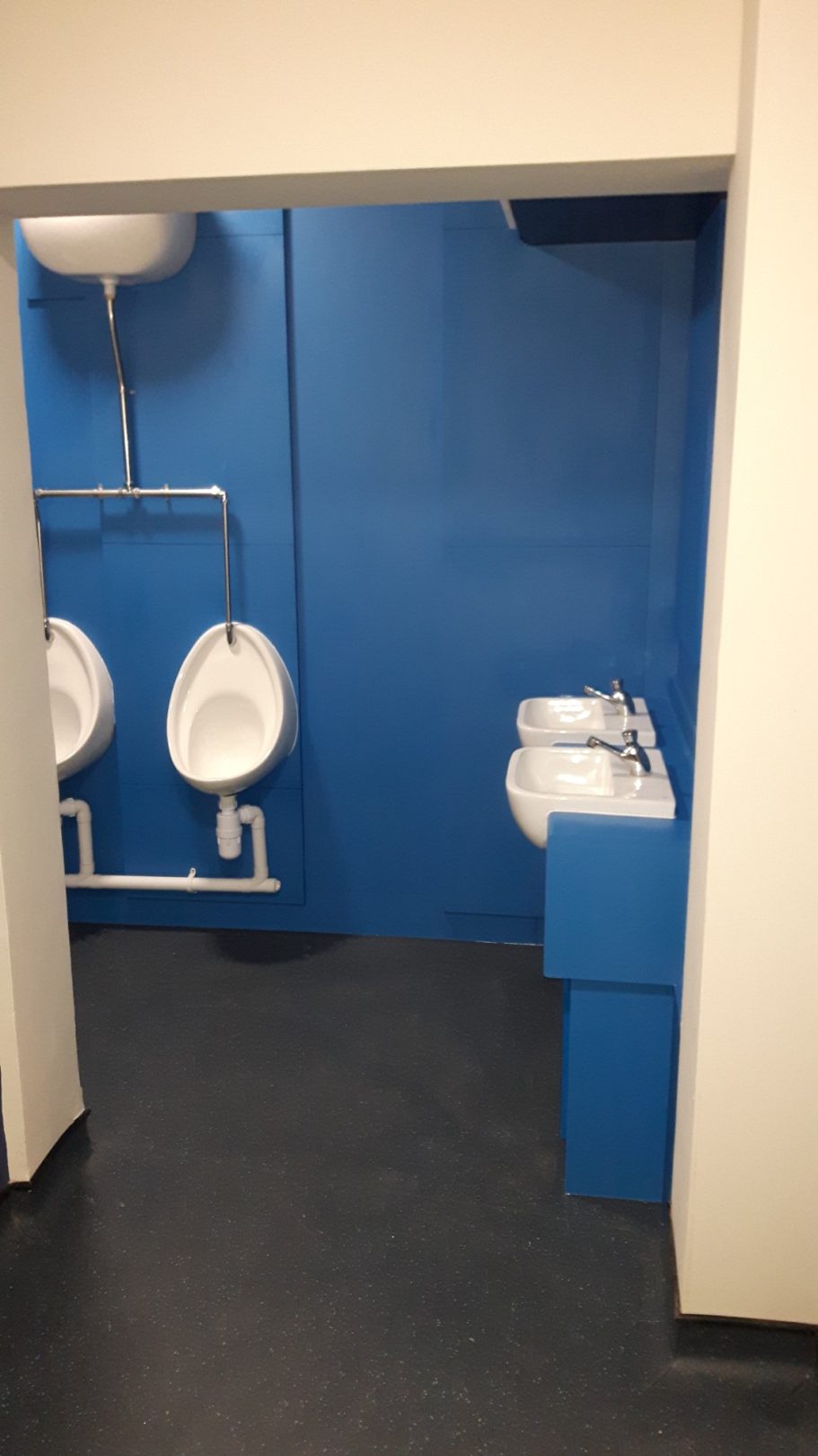 Gentlemen maintain privacy thanks to a stud wall shielding them from the foyer. Gentlemen maintain privacy thanks to a stud wall shielding them from the foyer.