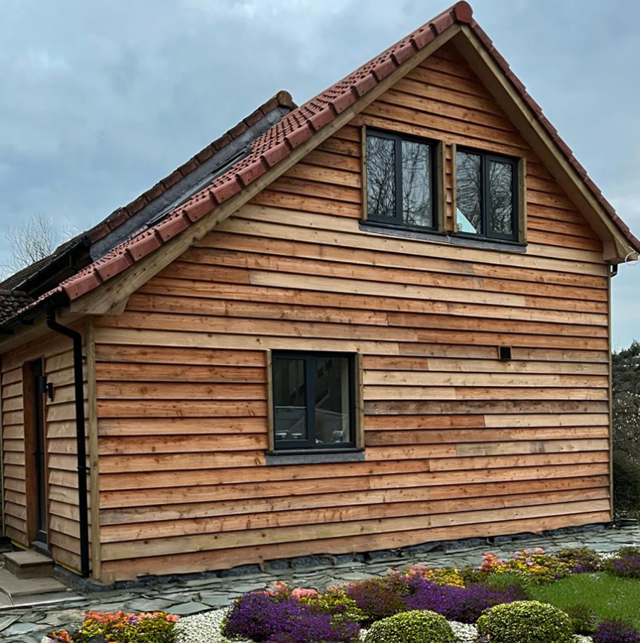 External view of larch timber framed extension as viewed from the access track and driveway in Axminster, disabled accommodation. External view of larch timber framed extension. Axminster disabled accommodation.