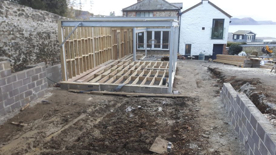 Land was reduced in height by about 12 feet and a new retaining wall and footing added. Land was reduced in height by about 12 feet and a new retaining wall and footing added. Then a steel frame was erected on this concrete.