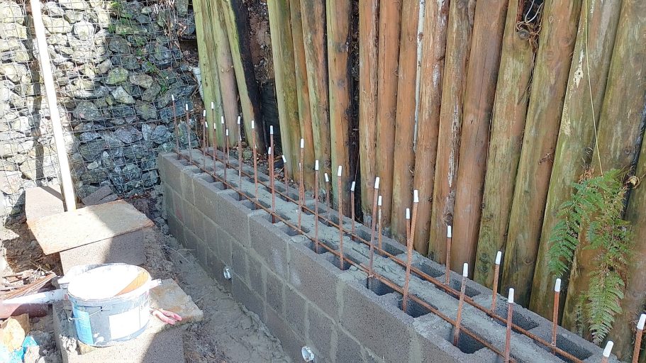 Horizontal rebar is added on every course of blocks to key the wall into one solid mass. Horizontal rebar is added on every course of blocks to key the wall into one solid mass.