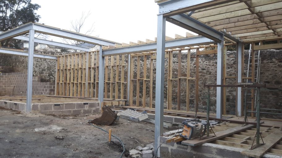 Reinforced concrete retaining wall goes down about 4 feet to underpin the old stone wall. Reinforced concrete retaining wall goes down about 4 feet to underpin the old stone wall.