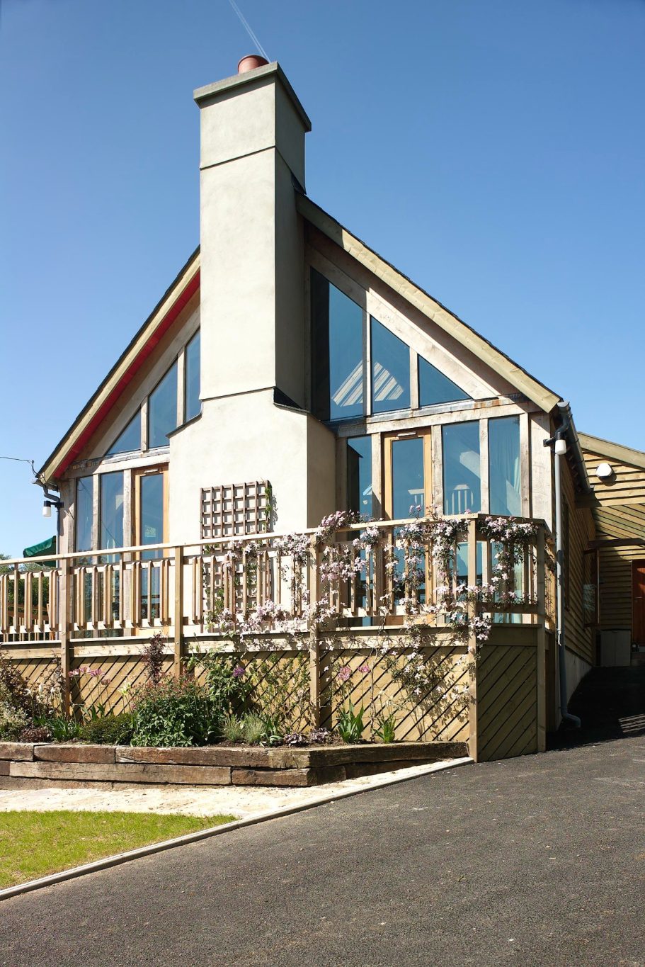 The view from the access driveway shows the glass wall on the front elevation. The view from the access driveway shows the glass wall on the front elevation.